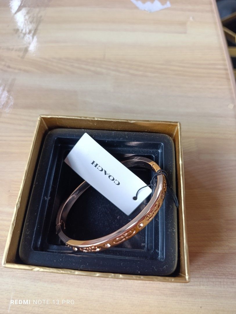 Authenthic 💯 Coach Rose Gold Bangle Bracelet (Category: Bracelets) located in Naguilian. Submitted by jhoyukay (Listing ID 1470687789, Image 3). Description: - Authentic Coach bangle in stunning rose gold - Classic signature C pattern engraved all around with sparkling crystal accents - Convenient and secure hinged clasp closure on the side for easy wear - Features the Coach New York logo stamped on the inner band - Brand new with original brand