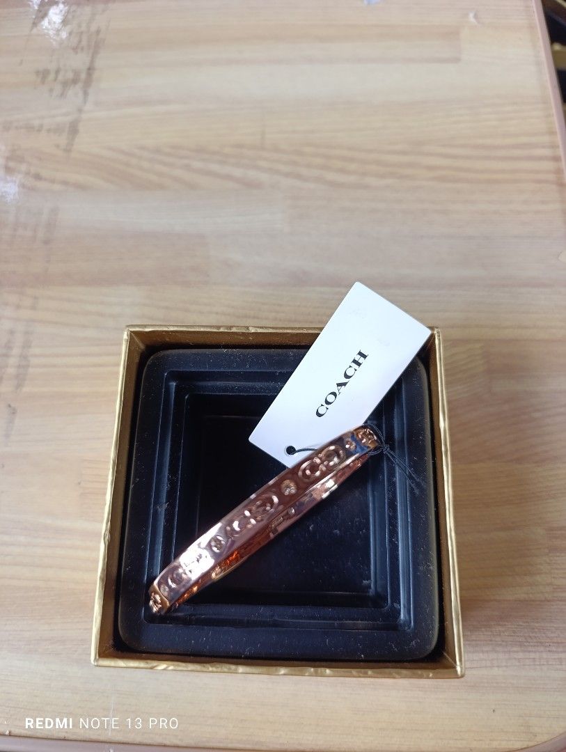 Authenthic 💯 Coach Rose Gold Bangle Bracelet (Category: Bracelets) located in Naguilian. Submitted by jhoyukay (Listing ID 1470687789, Image 2). Description: - Authentic Coach bangle in stunning rose gold - Classic signature C pattern engraved all around with sparkling crystal accents - Convenient and secure hinged clasp closure on the side for easy wear - Features the Coach New York logo stamped on the inner band - Brand new with original brand