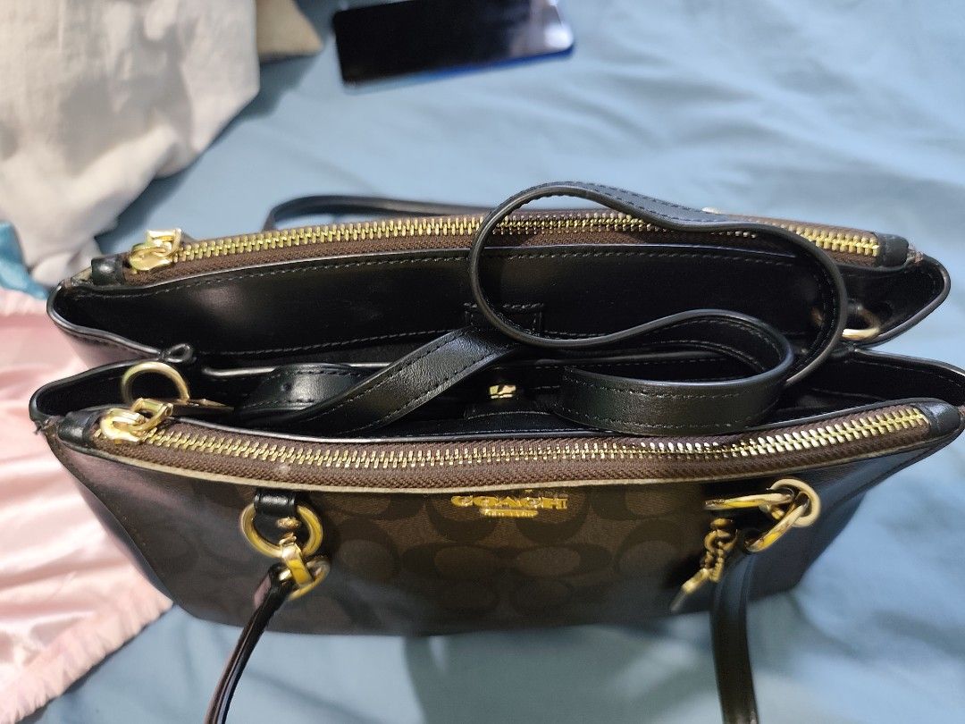 Coach Signature Brown Monogram Leather Handbag (Category: Luxury Bags & Wallets) located in Subic. Submitted by ferrero1982 (Listing ID 1470633141, Image 2). Description: - Authentic Coach shoulder bag in dark brown/black monogram & leather - Elegant gold-tone hardware and front logo lettering - Structured design with secure multiple compartments and top zip closure - Dual black leather top handles for comfortable wear - Includes signature matchi