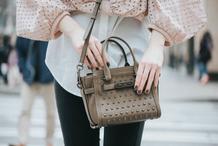 Coach Taupe Leather Studded Satchel Handbag (Category: Luxury Bags & Wallets) located in Cardona. Submitted by jaxdelossa10453 (Listing ID 1470612331, Image 2). Description: - Style: Taupe pebbled leather satchel with dark gunmetal hardware - Design: Fully covered metal-studded front with a secure turnlock closure - Carry options: Dual top handles + side rings ready for an optional crossbody strap - Extras: Includes matching leather hang tag - Ba