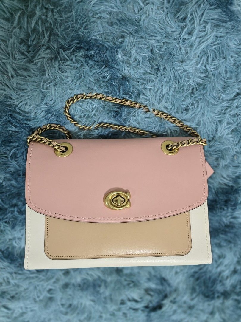 Coach Tri-Color Leather Shoulder Bag with Chain Strap (Category: Shoulder Bags) located in Bacolod City. Submitted by herclosetjoy (Listing ID 1470648278, Image 1). Description: - Brand: Coach - Design: Stylish tri-color (pink flap, tan front pocket, white base) - Hardware: Gold-tone with secure front turn-lock closure - Strap: Double chain strap interwoven with leather - Finish: Clean structure with smooth leather - Size: Perfect everyday bag fo