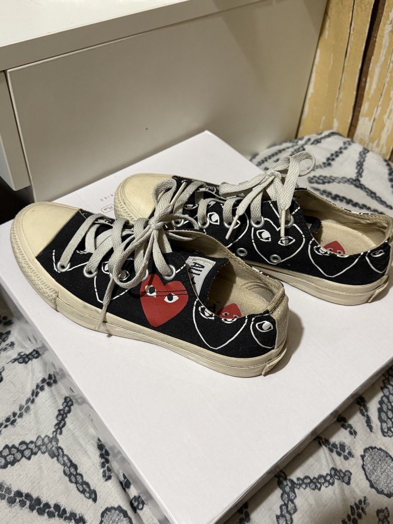 Comme des Garcons PLAY x Converse Multi-Heart Black Low Top (Category: Sneakers) located in Muntinlupa City. Submitted by biancaagbscloset (Listing ID 1470724140, Image 2). Description: Collaboration low top sneakers in black canvas. White graphic heart print with eyes pattern all over, plus the signature red heart on the side. Contrast white rubber toe cap and midsole. White laces through silver eyelets. Tag indicates size US 3 / JPN 22 CM.