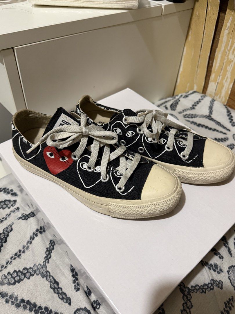 Comme des Garcons PLAY x Converse Multi-Heart Black Low Top (Category: Sneakers) located in Muntinlupa City. Submitted by biancaagbscloset (Listing ID 1470724140, Image 1). Description: Collaboration low top sneakers in black canvas. White graphic heart print with eyes pattern all over, plus the signature red heart on the side. Contrast white rubber toe cap and midsole. White laces through silver eyelets. Tag indicates size US 3 / JPN 22 CM.