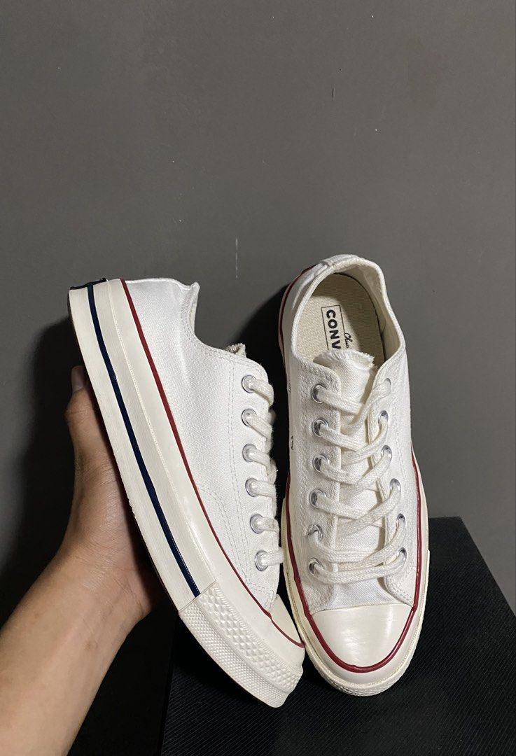 Converse Chuck 70 Low Top White Canvas Sneakers (Category: Sneakers) located in Manila. Submitted by smart_archives2000 (Listing ID 1470612942, Image 1). Description: Converse Chuck 70 low top sneakers in classic white canvas. Contrast red and blue pinstripe detailing along the midsole. Vintage style license plate logo on the heel. Silver eyelets and chunky rubber toe cap. Size is US Men 6.5 / Women 8.5. Clean condition all around..