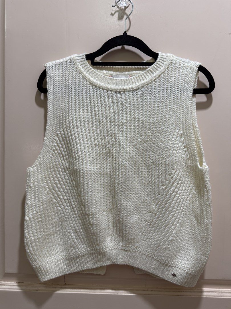 Cream Knit Vest Sleeveless Top Open Back (Category: Sleeveless) located in Davao. Submitted by 2ndbase.dvo.ii (Listing ID 1470597712, Image 2). Description: - Cream knitted sleeveless top - Classic round neckline with ribbed hem - Unique split back design for extra movement - Textured knit pattern on the front panels - Subtle metallic logo tag near the bottom hem - Easy to layer or wear solo for casual days.