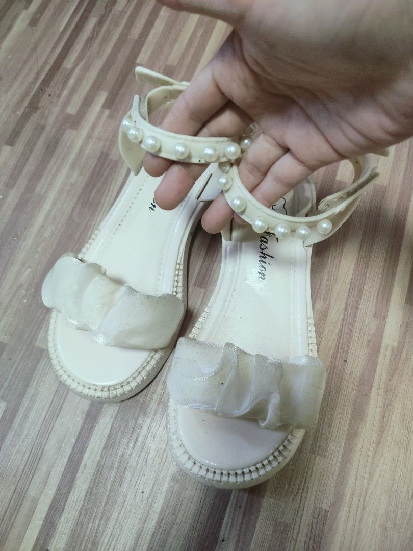 Cream Sandals with Pearl Strap and Bow (Category: Babies & Kids Fashion) located in San Jose del Monte. Submitted by helloitsmecamiel (Listing ID 1470560355, Image 1). Description: - kids size 22cm - Color: Cream - Design: Flat sandals with a statement sheer bow on the front strap - Details: Elegant pearl embellishments on the ankle strap and a dainty bow at the back heel - Closure: Easy slip-on style with a secure Velcro strap - Comfort: Cushion