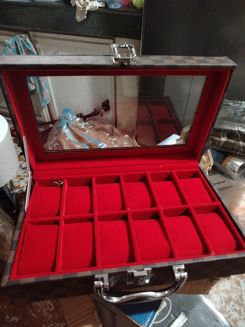 Damier Ebene Watch Box Storage Case with Handle (Category: Accessory Holder, Box & Organizers) located in Quezon City. Submitted by shewool (Listing ID 1470590284, Image 3). Description: - Brown checkerboard pattern exterior - Holds 10 watches on individual plush red velvet pillows - Clear display window on the top lid for easy viewing - Sturdy silver metal handle and secure clasp closure - Hard structured case keeps your collection organized and