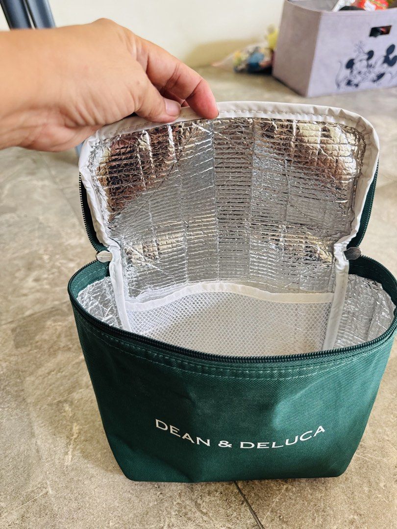 DEAN & DELUCA Green Cooler Lunch Bag (Category: Luxury Bags & Wallets) located in Santa Cruz. Submitted by maqui15 (Listing ID 1470670457, Image 3). Description: - Brand: Dean & Deluca - Color: Dark green with white printed logo - Material: Durable canvas-like exterior - Insulation: Silver foil thermal lining (keeps food warm or cold) - Features: Zip-around closure, top grab handle, and interior mesh pocket - Ideal for: Work, school, picnics, and