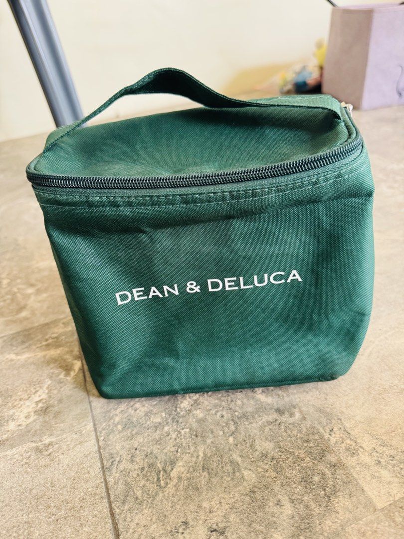 DEAN & DELUCA Green Cooler Lunch Bag (Category: Luxury Bags & Wallets) located in Santa Cruz. Submitted by maqui15 (Listing ID 1470670457, Image 1). Description: - Brand: Dean & Deluca - Color: Dark green with white printed logo - Material: Durable canvas-like exterior - Insulation: Silver foil thermal lining (keeps food warm or cold) - Features: Zip-around closure, top grab handle, and interior mesh pocket - Ideal for: Work, school, picnics, and