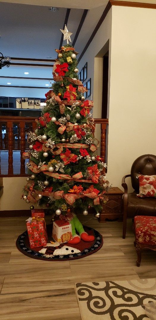 Decorated Artificial Christmas Tree with Ornaments (Category: Artificial Plants & Flowers) located in Cabanatuan. Submitted by veronica_md (Listing ID 1470663939, Image 2). Description: - 10ft Fully decorated artificial Christmas tree, ready for the holidays - Adorned with red poinsettia flowers, silver and gold baubles, and festive patterned ribbons - Includes a star topper for the finish - Comes with a stylish tree skirt and decorative wrapped 