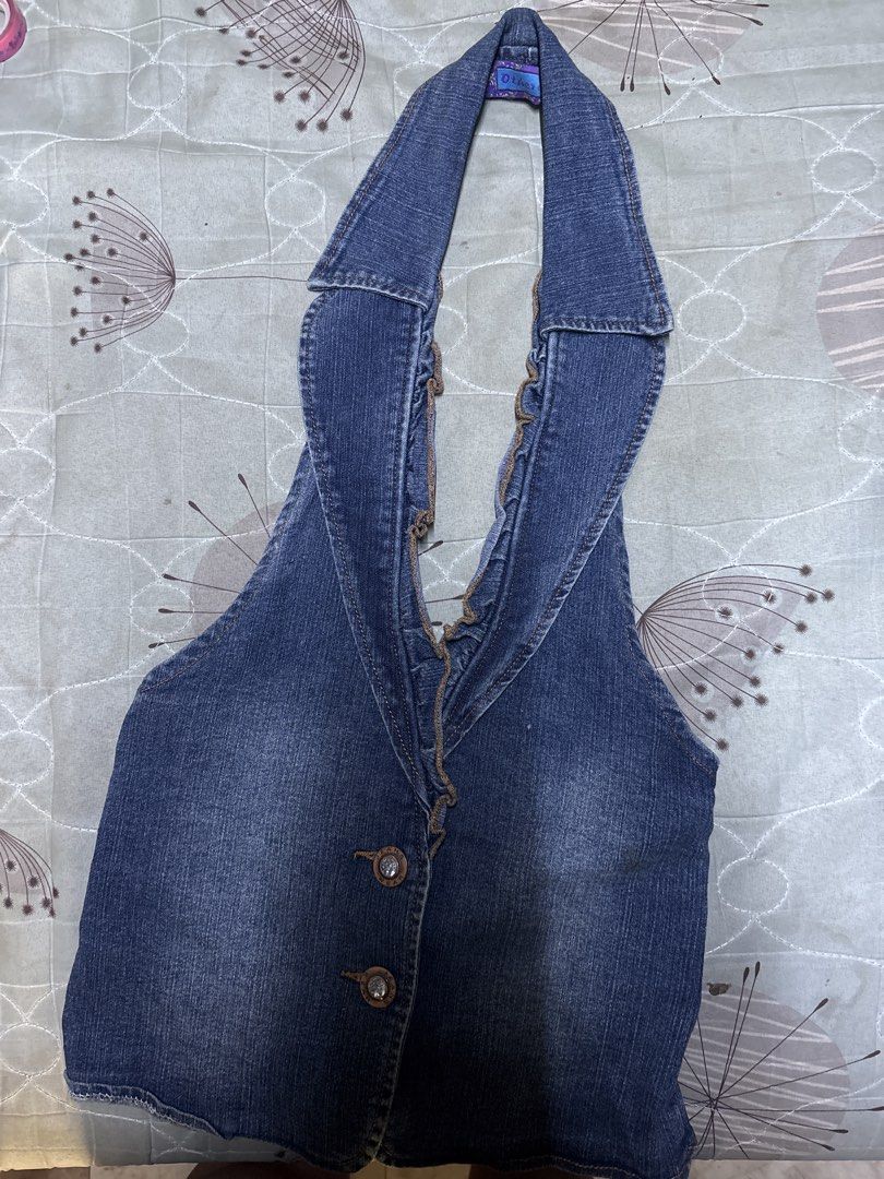 Denim halter top vest with ruffle trim (Category: Sleeveless) located in Caloocan City. Submitted by boldcrystal.64c51d (Listing ID 1470565480, Image 1). Description: - Style: Dark wash denim halter top - Neckline: Deep V-neck with frayed ruffle trim - Closure: Front button with two decorative buttons - Back Details: Elastic band at the waist and overlapping denim pocket-like details at the hem - Material: Comfortable blue denim - Condition: Bran