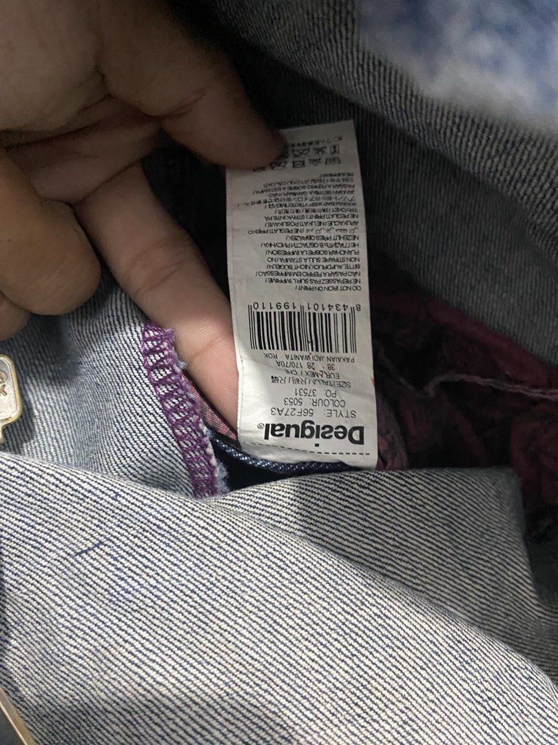 Desigual Denim Skirt Size 38 (Category: Skirts) located in Bulacan. Submitted by _myarchive (Listing ID 1470569548, Image 3). Description: - Brand: Desigual - Type: Denim Skirt - Size: 38 - Color: Blue with red patterned waistband - Closure: Asymmetrical button fly - Details: Distressed front, red embroidered logo on the front pocket - Back: Asymmetrical pockets with colorful embroidered detailing.