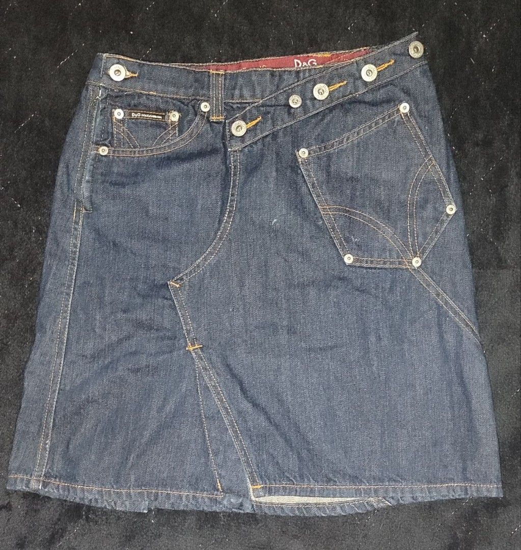 D&G Dolce & Gabbana Denim Skirt (Category: Skirts) located in Manila. Submitted by cosmictree_1321 (Listing ID 1470579049, Image 3). Description: - Brand: D&G Dolce & Gabbana - Style: Vintage Y2K asymmetric crossover denim skirt - Wash: Dark blue with contrast stitching and panel construction - Details: Branded metal buttons, rivets, and small coin pocket with woven logo label - Material: 100% cotton outer - Origin: Made in Italy - Condition: Exc