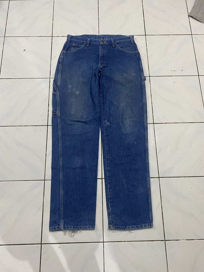 Dickies Blue Denim Carpenter Jeans (Category: Jeans) located in Cavite. Submitted by findsmore (Listing ID 1470742945, Image 2). Description: - Brand: Dickies - Color: Blue denim - Style: Classic utility carpenter jeans with straight leg fit - Features: Side tool pockets, hammer loop, button closure, and belt loops - Condition: Worn-in workwear look with natural fading, light front stains, and frayed ankle hems.
