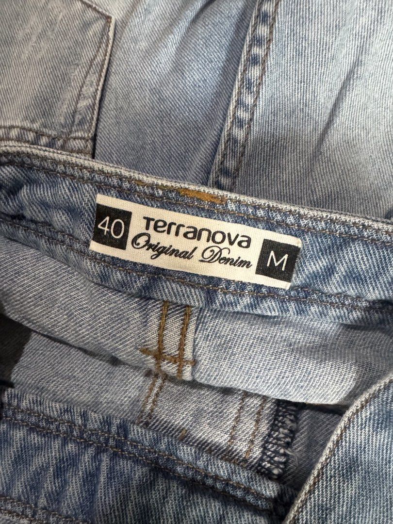 Distressed Denim Overalls (Category: Jumpsuits) located in Pasig City. Submitted by kia.sell (Listing ID 1470652058, Image 3). Description: - Brand: Terranova (100% Authentic) - Style: Full-length distressed denim overalls / dungarees - Color: Light Wash Blue - Design Details: Adjustable overall shoulder straps with metal clasp fasteners, intentional raw shredded rip detailing along the legs, a multi-pocket bib chest layout, classic side-button h