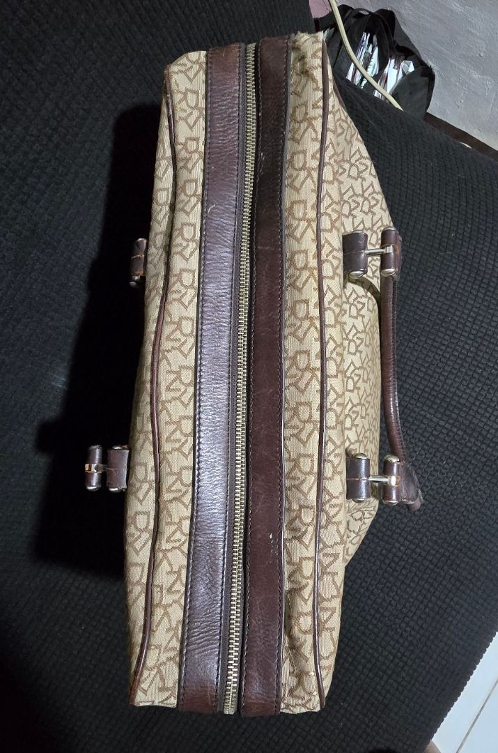 DKNY monogram canvas bag - Negotiable!!! (Category: Luxury Bags & Wallets) located in Manila. Submitted by axelyuna.27 (Listing ID 1470573648, Image 3). Description: Authentic DKNY beige monogram canvas bag with brown leather trim and cute heart charm. Features a zip top, secure pockets inside and out, and some visible scuffing on the leather base. Still a stylish and roomy daily bag at a great price!.