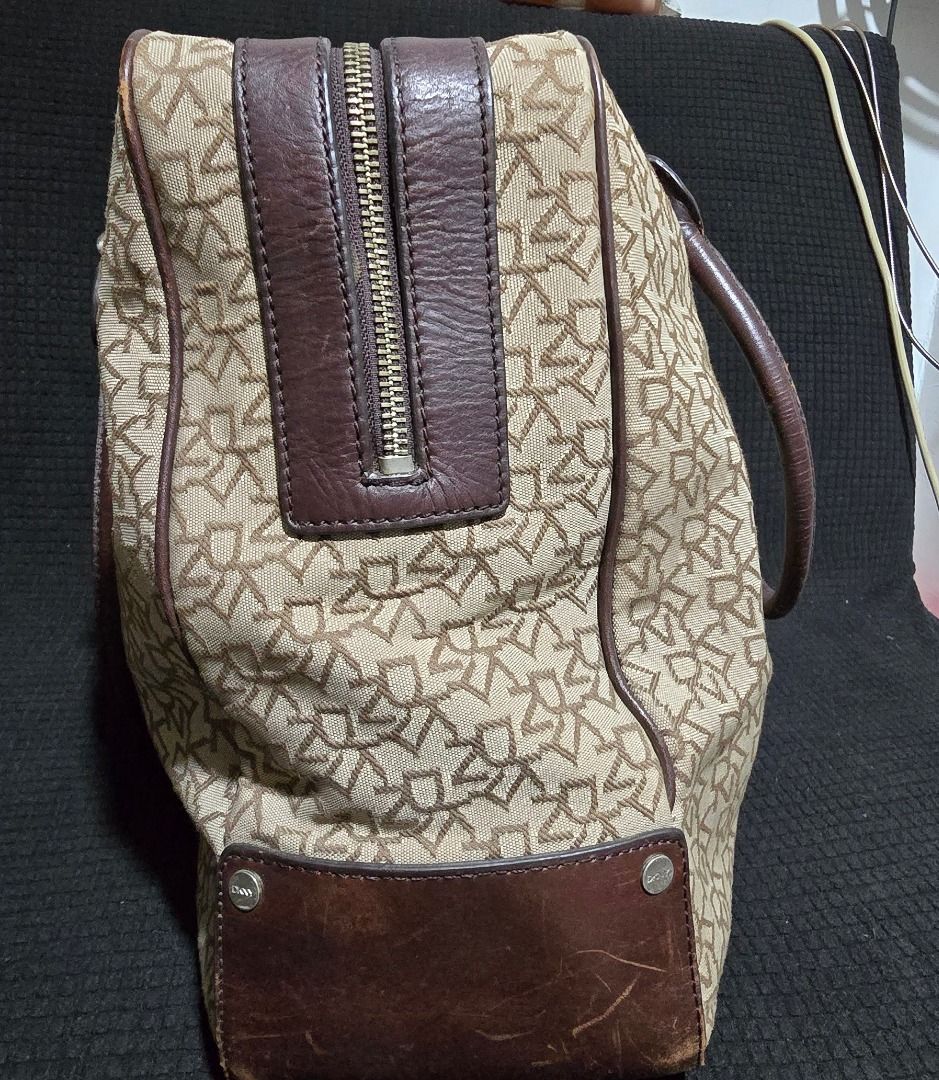 DKNY monogram canvas bag - Negotiable!!! (Category: Luxury Bags & Wallets) located in Manila. Submitted by axelyuna.27 (Listing ID 1470573648, Image 2). Description: Authentic DKNY beige monogram canvas bag with brown leather trim and cute heart charm. Features a zip top, secure pockets inside and out, and some visible scuffing on the leather base. Still a stylish and roomy daily bag at a great price!.