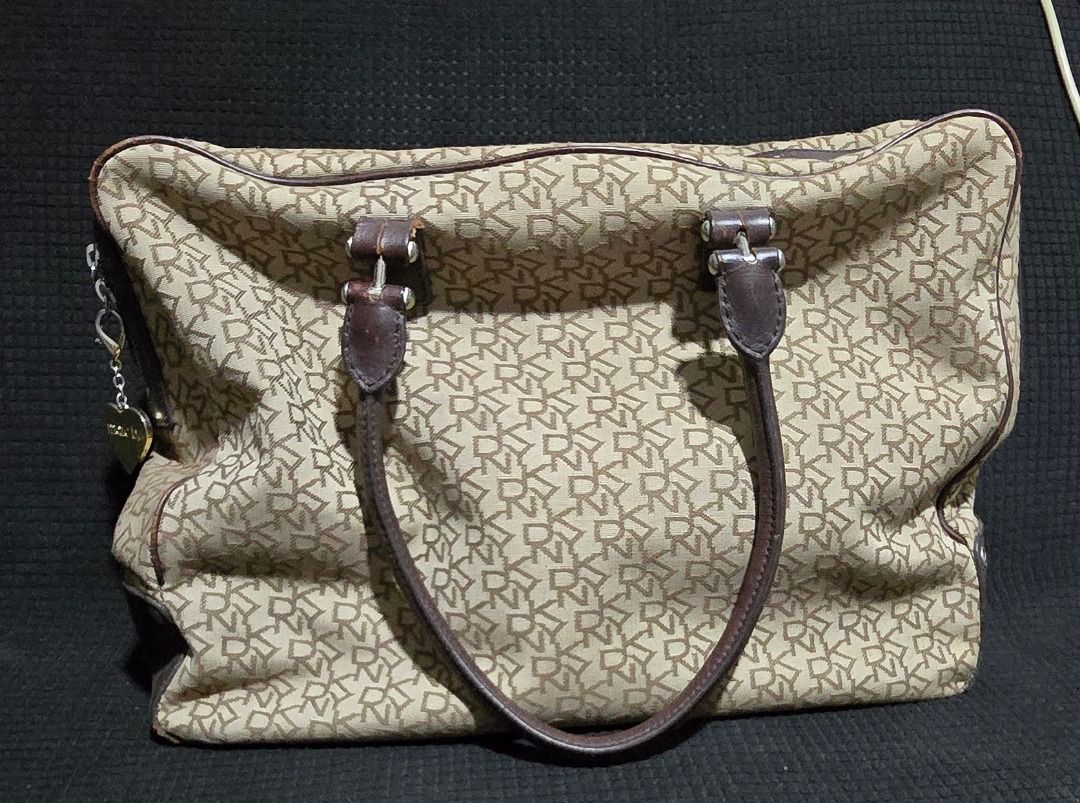 DKNY monogram canvas bag - Negotiable!!! (Category: Luxury Bags & Wallets) located in Manila. Submitted by axelyuna.27 (Listing ID 1470573648, Image 1). Description: Authentic DKNY beige monogram canvas bag with brown leather trim and cute heart charm. Features a zip top, secure pockets inside and out, and some visible scuffing on the leather base. Still a stylish and roomy daily bag at a great price!.