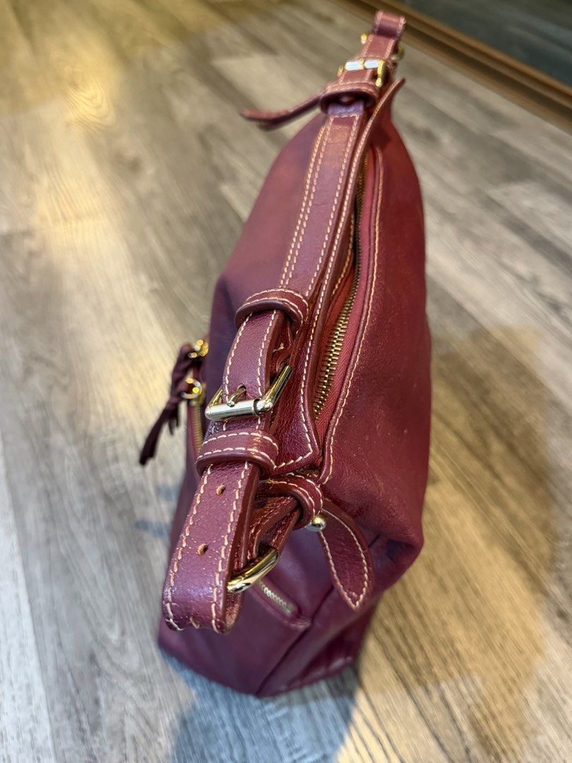 Dooney & Bourke Maroon Leather Shoulder Bag (Category: Luxury Bags & Wallets) located in Makati City. Submitted by bagattic_etc (Listing ID 1470687224, Image 2). Description: Brand/Model: Dooney & Bourke Leather Shoulder Bag Color: Rich maroon with contrast stitching Hardware: Premium gold-tone hardware and metal brand logo plate Storage: Spacious main compartment and front exterior zip pocket Details: Braided leather zipper pulls and adjustable 
