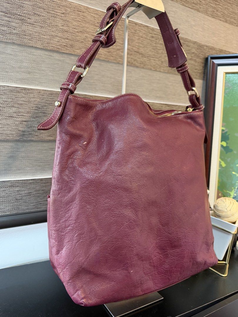 Dooney & Bourke Maroon Leather Shoulder Bag (Category: Luxury Bags & Wallets) located in Makati City. Submitted by bagattic_etc (Listing ID 1470687224, Image 3). Description: Brand/Model: Dooney & Bourke Leather Shoulder Bag Color: Rich maroon with contrast stitching Hardware: Premium gold-tone hardware and metal brand logo plate Storage: Spacious main compartment and front exterior zip pocket Details: Braided leather zipper pulls and adjustable 