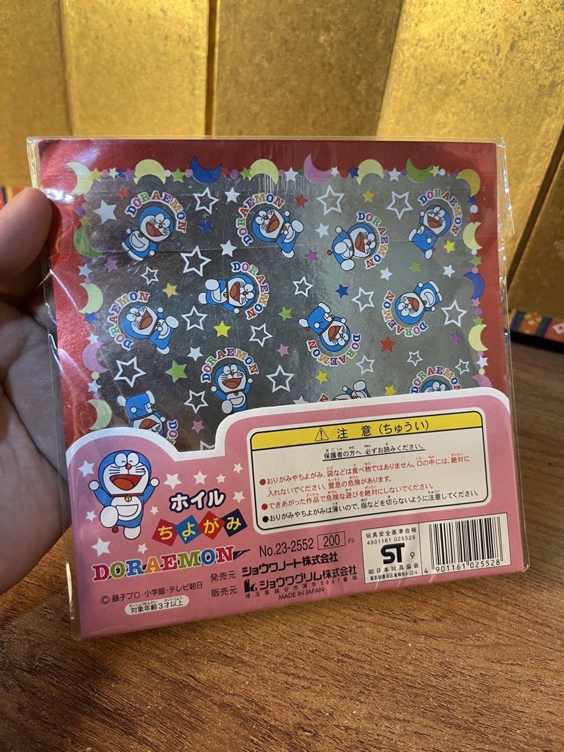 Doraemon foil chiyogami origami paper pack (Category: Craft Supplies & Tools) located in Gapan. Submitted by lunashop14 (Listing ID 1470627835, Image 2). Description: - Authentic Doraemon foil chiyogami origami paper, made in Japan by Shogwacraft - Brand new and unopened pack - Size: 145mm x 145mm - Includes 8 sheets total with 4 vibrant color tones - Features a beautiful shiny foil finish, perfect for various craft projects.