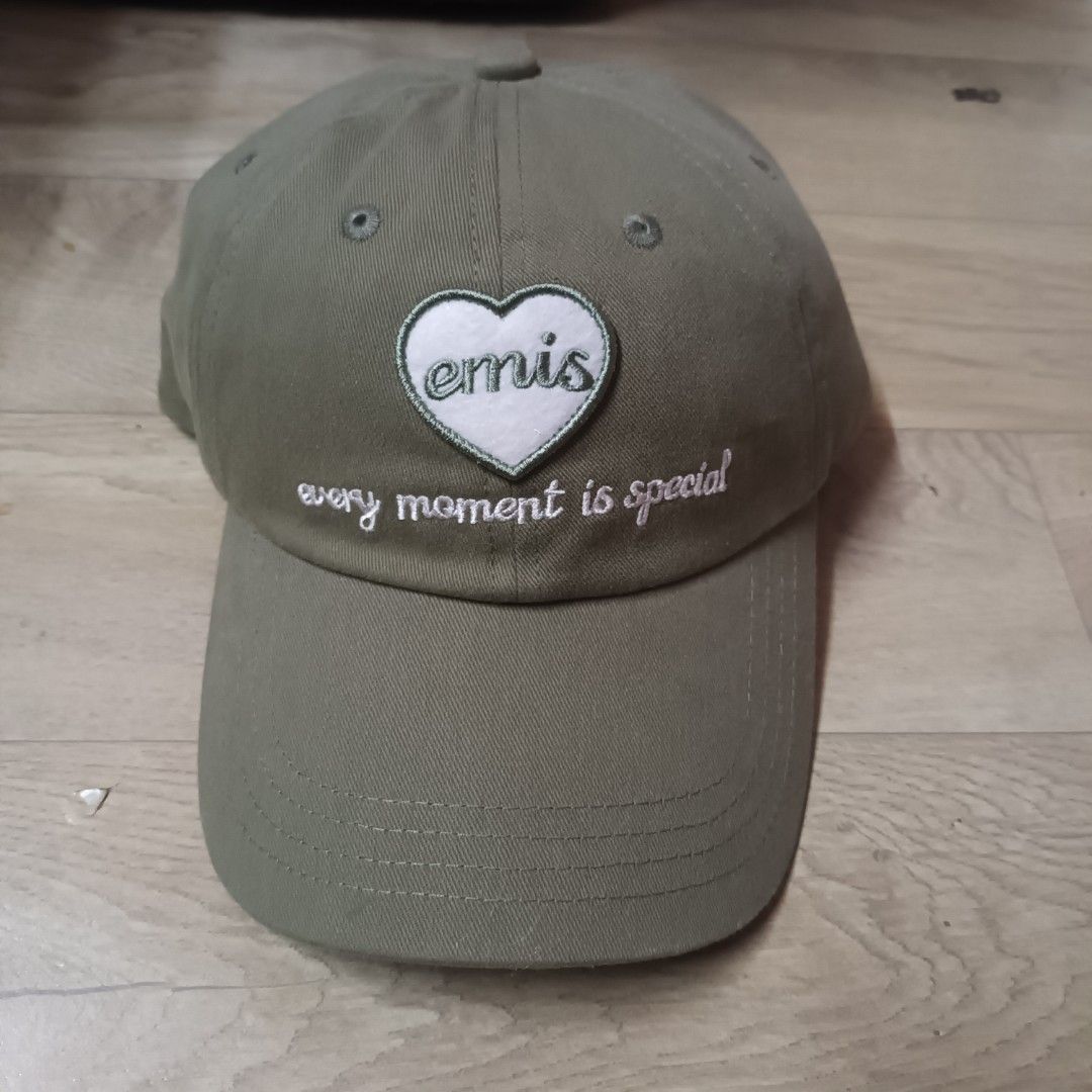 Emis Heart Logo Cap (Category: Caps & Hats) located in Manila. Submitted by itsnik444 (Listing ID 1470639818, Image 1). Description: - Brand: Emis - Color: Olive green - Design: Embroidered heart patch with 'emis' text and 'every moment is special' lettering - Material: 100% cotton - Closure: Adjustable strapback with branded metal buckle - Details: Branded interior taping and tag - Condition: Clean and ready to wear.