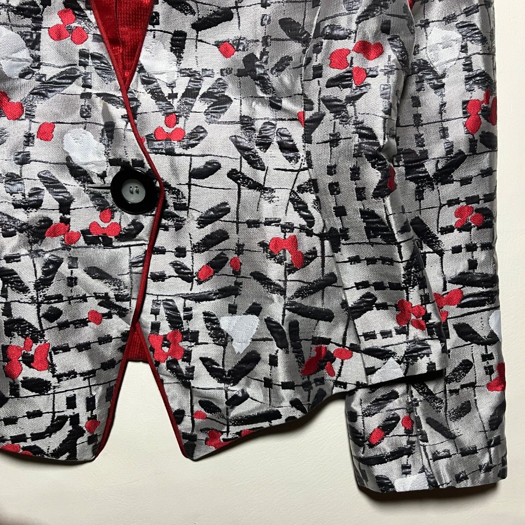 Emporio Armani Silver Red Patterned Blazer Jacket (Category: Coats, Jackets and Outerwear) located in Caloocan City. Submitted by achilles_grails (Listing ID 1470728063, Image 3). Description: - Brand: Emporio Armani designer blazer - Color/Pattern: Silver grey base with black abstract strokes and bright red floral accents - Design: Collarless neckline, single-button front closure, and curved hem - Lining: Striking red textured interior lining - 