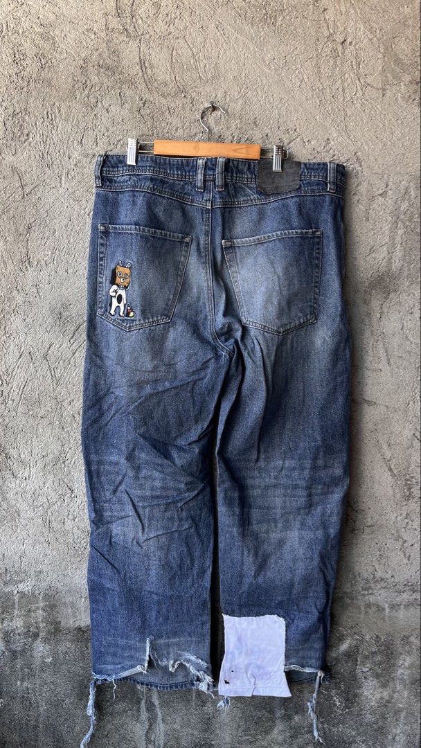 empyre Graphic Patch Denim Jeans (Category: Jeans) located in Cabuyao City. Submitted by bulandos (Listing ID 1470657407, Image 2). Description: - Material: 100% Cotton - Color: Medium wash blue - Style: Regular fit streetwear denim with button fly - Design details: Embroidered dog with bag on head graphic on back pocket - Unique features: Distressed/frayed hems with custom white fabric repair patch on the right cuff - Condition: Excellent / As g