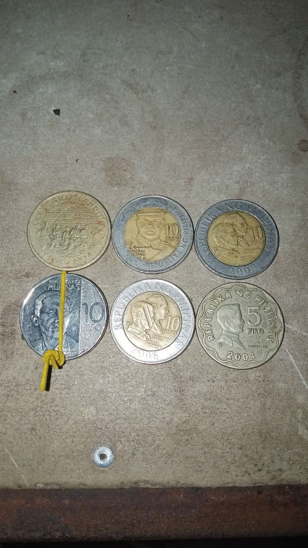 Error and commemorative coins., presyohan nyo na lang (Category: Currency) located in Caloocan City. Submitted by aaliyahsison09 (Listing ID 1470663374, Image 3). Description: - Philippine currency coin collection - Includes commemorative and standard designs - Features 10-peso bimetallic and 5-peso coins - Visible dates include 1998, 2003, and others - Shows natural discoloration and surface wear - Sold as a bundle lot secured with a rubber band