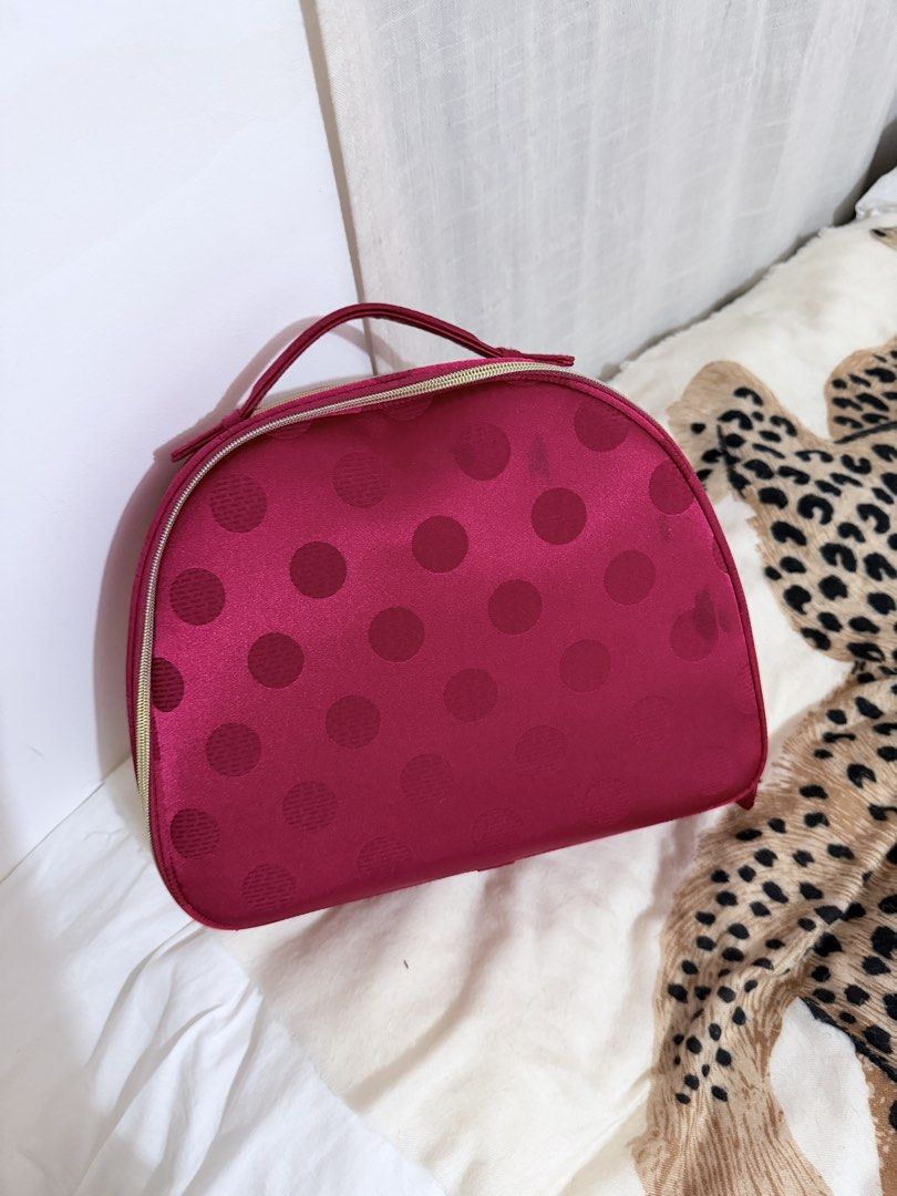 Estée Lauder Maroon Polka Dot Vanity Bag (Category: Purses & Pouches) located in Taguig. Submitted by mengxir20193848 (Listing ID 1470674658, Image 2). Description: - Brand: Estée Lauder - Color: Rich maroon with a subtle polka dot pattern - Material: Satin-like fabric - Hardware: Gold-tone zippers with engraved Estée Lauder logo pulls - Interior: Pink fabric lining with a convenient slip pocket - Features: Sturdy top handle and wide zip-around c