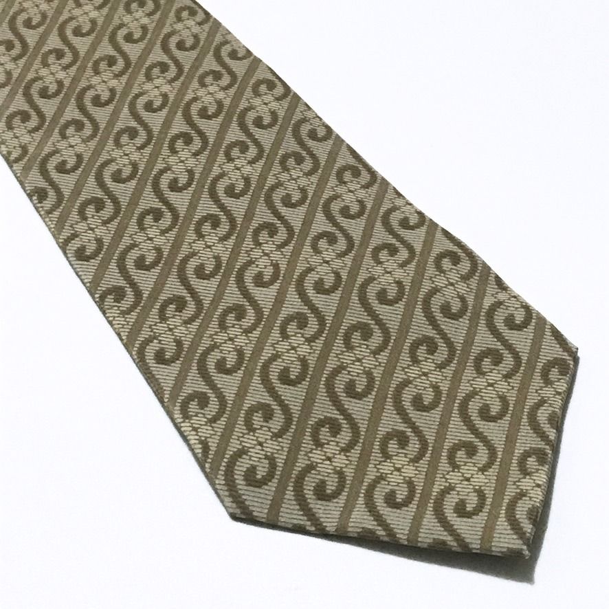 Excellent Geometric Stripes Pattern Beige Neck Tie (Category: Ties) located in Taguig. Submitted by retrogaze (Listing ID 1470706514, Image 2). Description: This 100% silk necktie by Excellent features a warm beige-champagne ground. The blade is decorated with a repeating geometric bias stripe pattern showcasing interlocking 'S'-scroll motifs and wavy ribbon tendrils in a taupe-brown shade. Recommended Suit & Shirt Pairings: • The Executive Class