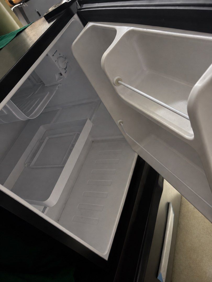 Ezy Compact Mini Fridge Black (Category: Refrigerators and Freezers) located in Angeles City. Submitted by vega.rachel (Listing ID 1470584883, Image 2). Description: - Color: Sleek black - Condition: Clean interior, well-maintained - Performance: Runs quietly and chills excellently - Features: Built-in temperature control dial and convenient door storage racks - Ideal for: Bedrooms, offices, or dorm rooms.