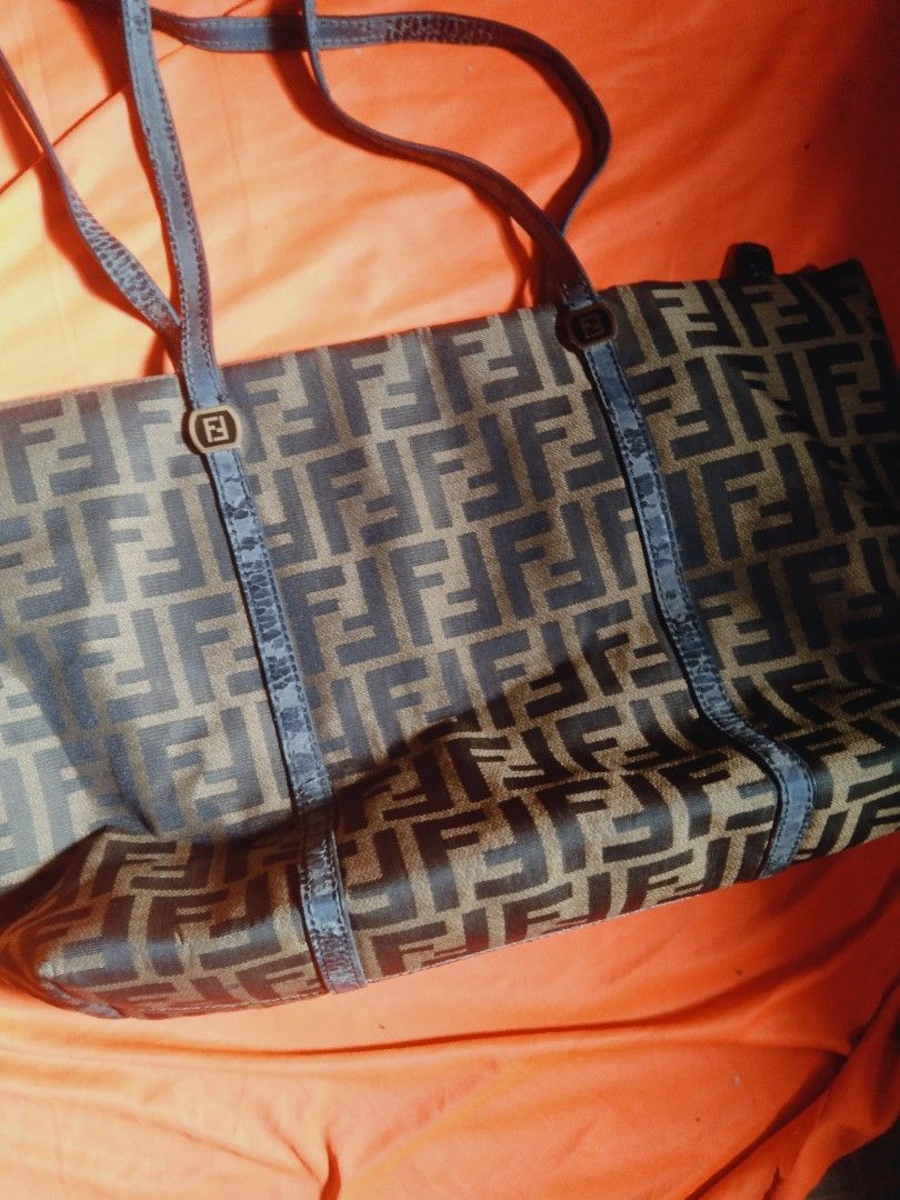 Fendi Zucca FF Logo Tote Bag (Category: Luxury Bags & Wallets) located in Manila. Submitted by pusturathrift (Listing ID 1470671482, Image 2). Description: off issue leather strap - Brand: Fendi - Style: Tote bag in iconic brown Zucca FF monogram canvas - Hardware: Gold-tone Fendi logo rings with zip top closure - Straps: Double shoulder straps with textured dark trim - Interior: Dark fabric lining with one zipper pocket - Authenticity/Serial: Ta
