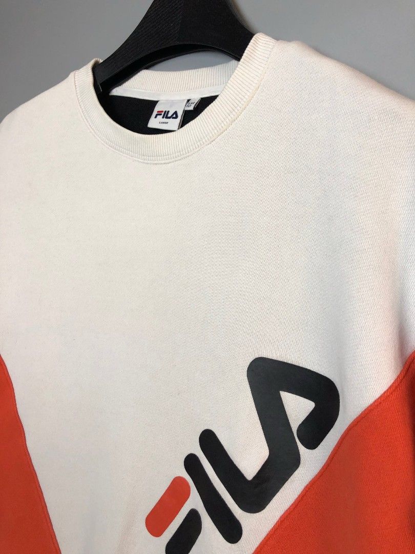 FILA Colourblock Crewneck Sweatshirt Large (Category: Coats, Jackets and Outerwear) located in Manila. Submitted by silentwolf_3303a7 (Listing ID 1470559158, Image 3). Description: - Brand: FILA - Design: White, orange, and black colourblock with a large diagonal front logo and sleeve patch - Interior: Thick fleece lining for extra warmth and comfort - Fit: Size Large (LSE fit) - Details: Ribbed collar, cuffs, and hem with original Korean care la