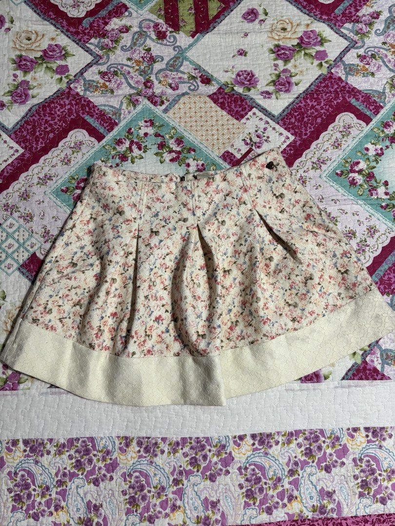Floral pattern pleated skirt with textured hem (Category: Skirts) located in Sual. Submitted by cinnamorol_lovar (Listing ID 1470624102, Image 1). Description: - Style: Short pleated skirt with a pretty pastel floral print - Details: Textured cream-colored hem band and secure back zipper closure - Fabric: Slightly weighted with good structure to hold the pleats nicely - Vibe: Cute and breezy, perfect for warmer weather.