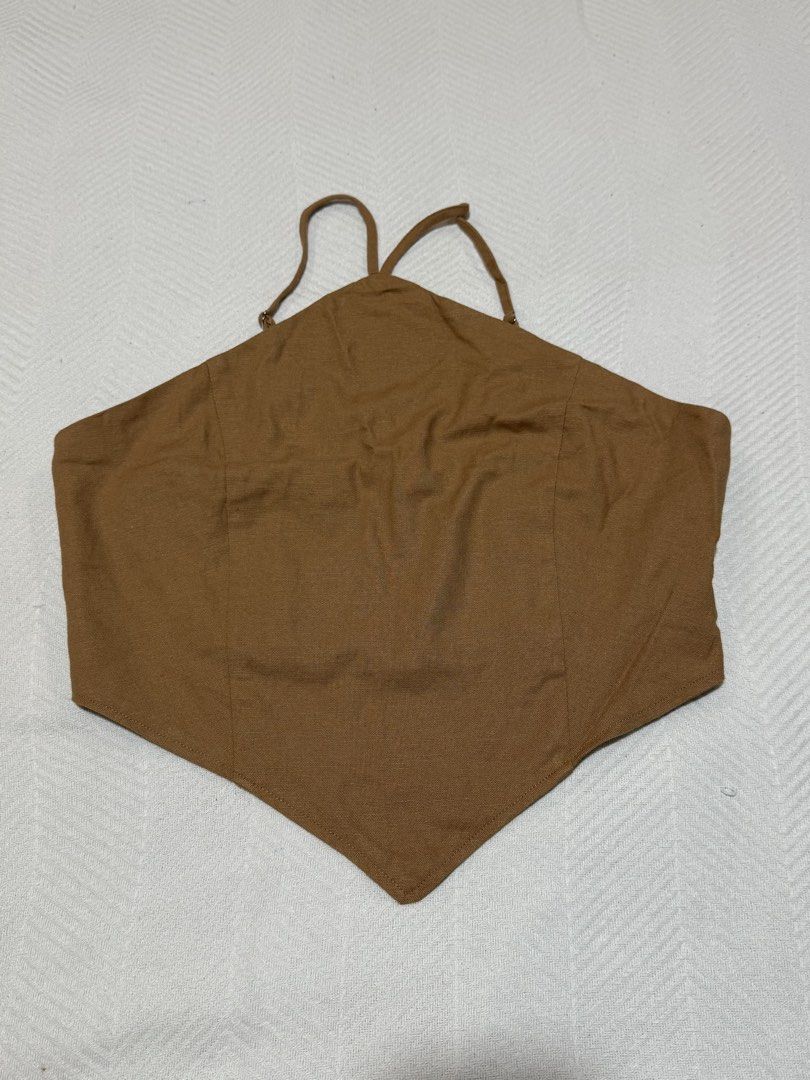 Forever 21 Brown Halter Crop Top Size M (Category: Sleeveless) located in Pateros City. Submitted by daisy03052000 (Listing ID 1470695979, Image 1). Description: - Brand: Forever 21 - Size: Medium - Color: Brown - Condition: Brand new with tags (BNWT), unworn - Features: Halter neck, triangular front hem, adjustable thin straps, elastic smocked back panel for a comfortable fit.