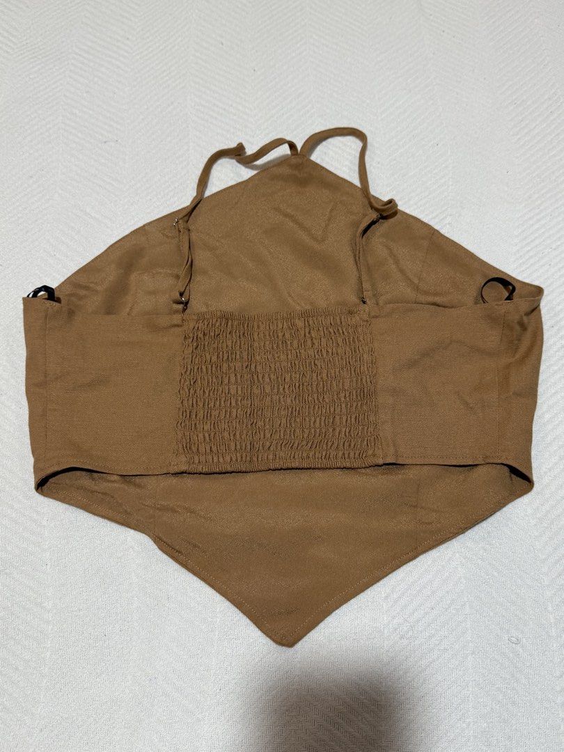 Forever 21 Brown Halter Crop Top Size M (Category: Sleeveless) located in Pateros City. Submitted by daisy03052000 (Listing ID 1470695979, Image 2). Description: - Brand: Forever 21 - Size: Medium - Color: Brown - Condition: Brand new with tags (BNWT), unworn - Features: Halter neck, triangular front hem, adjustable thin straps, elastic smocked back panel for a comfortable fit.