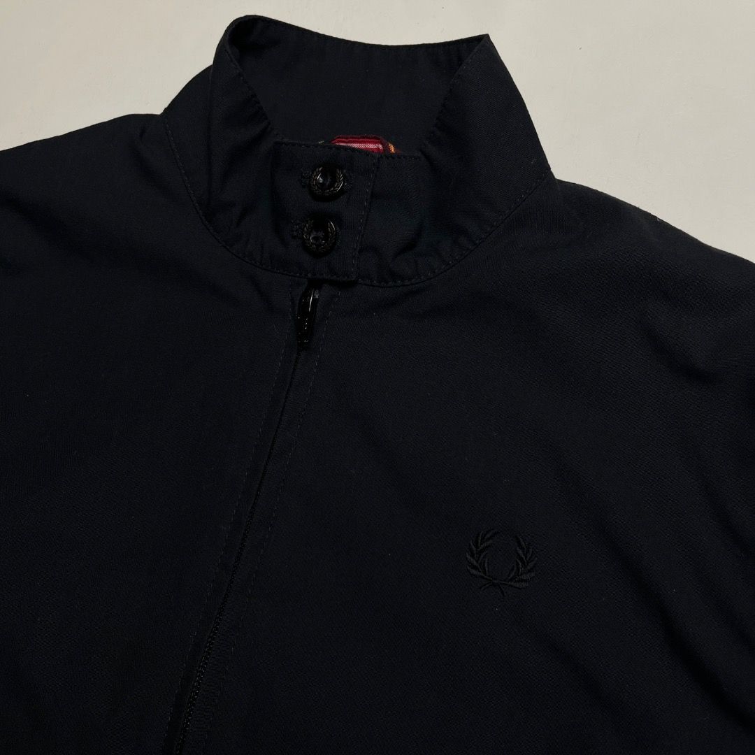 Fred Perry Harrington Jacket Black Made in England (Category: Coats, Jackets and Outerwear) located in Caloocan City. Submitted by achilles_grails (Listing ID 1470578868, Image 2). Description: - Authentic Fred Perry Harrington jacket in classic black, Made in England - Features iconic red tartan inner lining and signature embroidered laurel wreath on chest - High collar with double button fastening, full zip front, and ribbed cuffs and hem - She