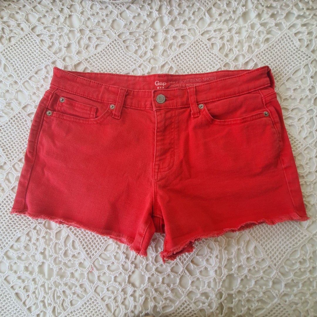 Gap Sexy Boyfriend Short Red Denim (Category: Shorts) located in Laoag. Submitted by soukay (Listing ID 1470580761, Image 1). Description: - Brand: Gap - Style: Sexy boyfriend denim shorts - Color: Bright red (great pop of color for summer) - Rise: Mid-rise - Details: Raw frayed hems, five-pocket styling, button fly closure, classic copper-tone hardware - Sizing: Measurements shown in the second photo with a tape measure - Condition: Excellent.