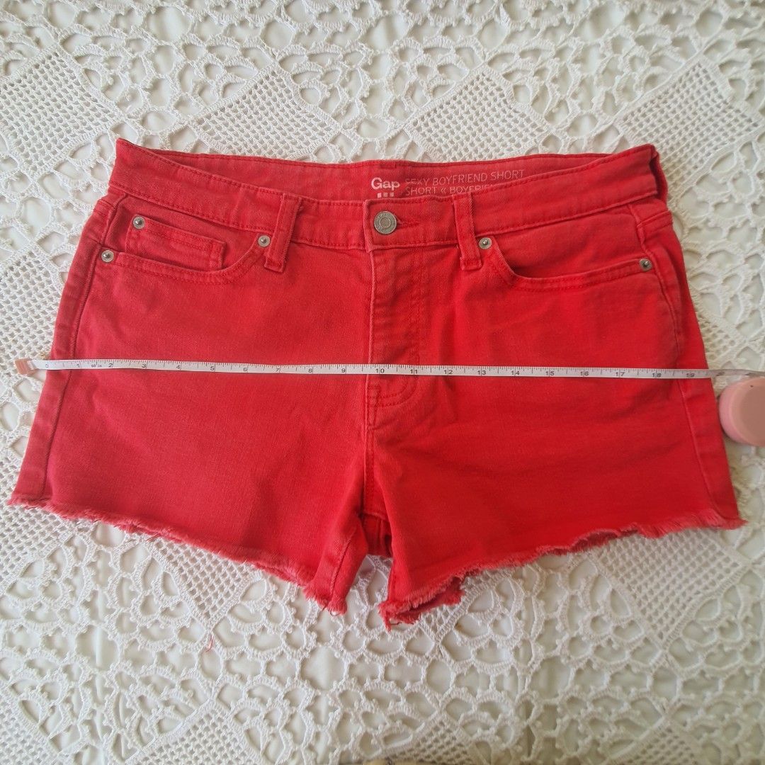 Gap Sexy Boyfriend Short Red Denim (Category: Shorts) located in Laoag. Submitted by soukay (Listing ID 1470580761, Image 3). Description: - Brand: Gap - Style: Sexy boyfriend denim shorts - Color: Bright red (great pop of color for summer) - Rise: Mid-rise - Details: Raw frayed hems, five-pocket styling, button fly closure, classic copper-tone hardware - Sizing: Measurements shown in the second photo with a tape measure - Condition: Excellent.
