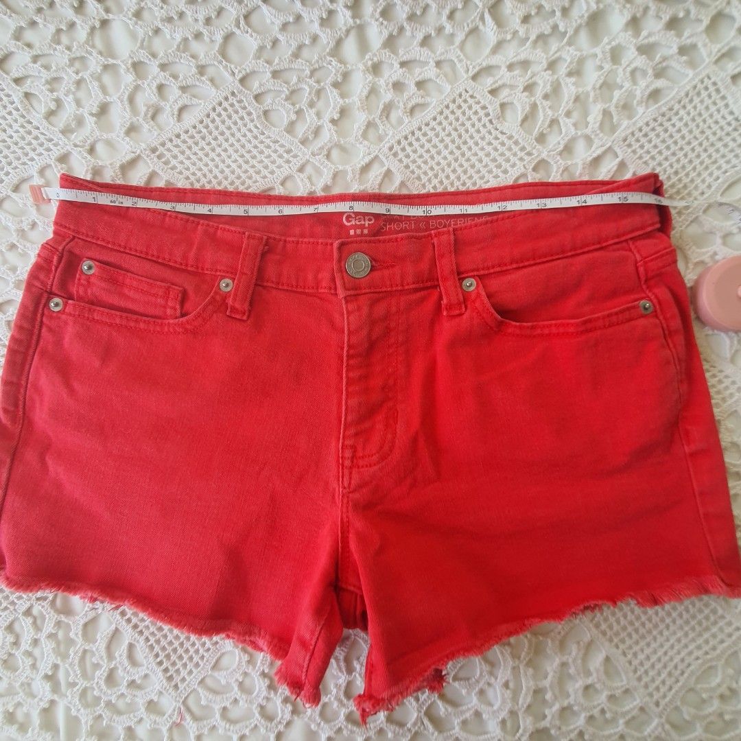 Gap Sexy Boyfriend Short Red Denim (Category: Shorts) located in Laoag. Submitted by soukay (Listing ID 1470580761, Image 2). Description: - Brand: Gap - Style: Sexy boyfriend denim shorts - Color: Bright red (great pop of color for summer) - Rise: Mid-rise - Details: Raw frayed hems, five-pocket styling, button fly closure, classic copper-tone hardware - Sizing: Measurements shown in the second photo with a tape measure - Condition: Excellent.