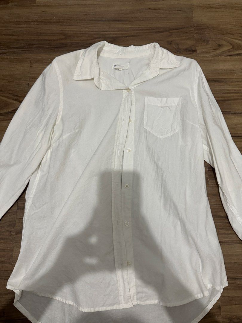 Gap White Boyfriend Fit Button Down Shirt Size S (Category: Shirts) located in Paranaque City. Submitted by declutterwyae (Listing ID 1470645674, Image 2). Description: - Brand: Gap - Color: Clean White - Size: Small - Style: Relaxed boyfriend fit - Details: Long sleeves with button cuffs, front chest pocket, curved hem, and classic collar - Condition: Excellent / Clean - Versatility: Perfect for casual or smart-casual outfits.