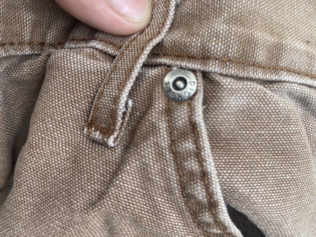 Genuine Dickies brown carpenter work pants (Category: Jeans) located in Imus. Submitted by frootiloots4103 (Listing ID 1470717556, Image 3). Description: - Brand: Genuine Dickies - Color: Brown - Material: Durable cotton blend, machine washable - Fit: Relaxed fit through the leg - Details: Button closure with metal hardware, multiple back pockets including a utility tool pocket - Condition: Slight fade with a small, character-adding distress mark