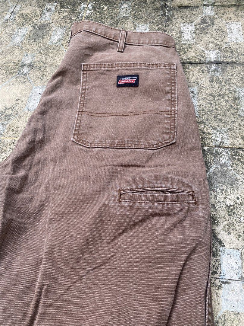 Genuine Dickies brown carpenter work pants (Category: Jeans) located in Imus. Submitted by frootiloots4103 (Listing ID 1470717556, Image 2). Description: - Brand: Genuine Dickies - Color: Brown - Material: Durable cotton blend, machine washable - Fit: Relaxed fit through the leg - Details: Button closure with metal hardware, multiple back pockets including a utility tool pocket - Condition: Slight fade with a small, character-adding distress mark
