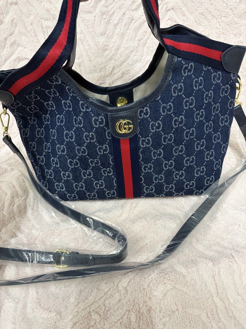 GG Denim Blue Giglio small (Category: Tote Bags) located in Quezon City. Submitted by arwenpasion (Listing ID 1470569434, Image 3). Description: - Giglio denim blue tote bag with classic GG monogram pattern - Features the signature red and blue web stripe down the center - Equipped with double top handles and an adjustable shoulder strap (still in plastic packaging) - Elegant gold-tone hardware with interlocking G logo - Light-colored fabric lini