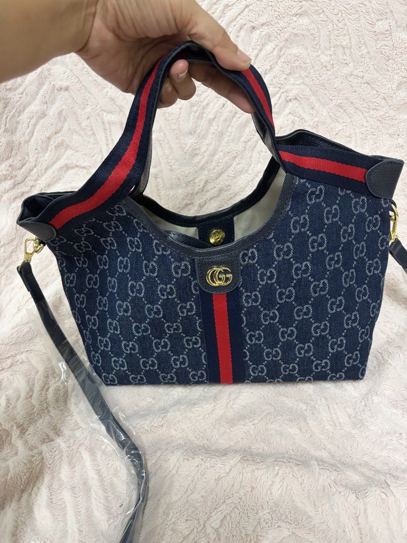 GG Denim Blue Giglio small (Category: Tote Bags) located in Quezon City. Submitted by arwenpasion (Listing ID 1470569434, Image 2). Description: - Giglio denim blue tote bag with classic GG monogram pattern - Features the signature red and blue web stripe down the center - Equipped with double top handles and an adjustable shoulder strap (still in plastic packaging) - Elegant gold-tone hardware with interlocking G logo - Light-colored fabric lini