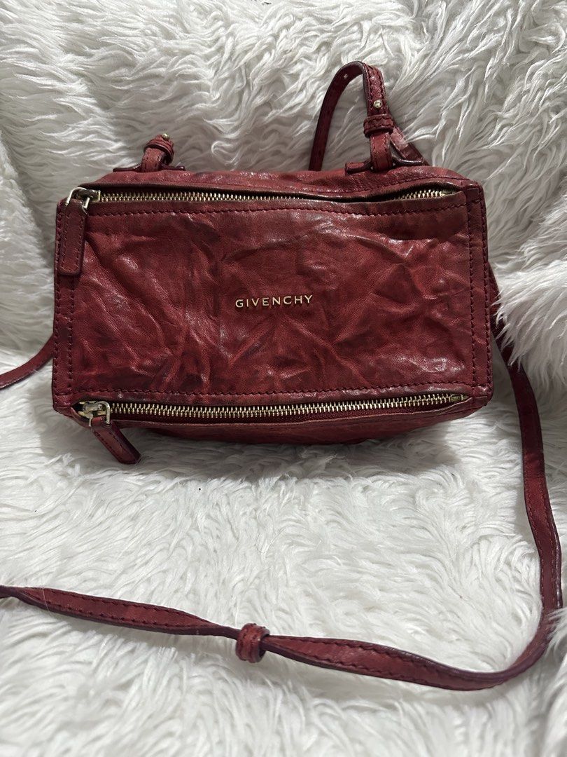 Givenchy Red Leather Pandora Mini Crossbody Bag (Category: Luxury Bags & Wallets) located in Marilao. Submitted by curleylux (Listing ID 1470586768, Image 1). Description: Givenchy Pandora crossbody bag in crinkled red leather. Gold tone hardware and zipper closures. Bold GIVENCHY logo lettering stamped across the front. Adjustable thin strap attached. Boxy silhouette with slight softening at the corners. Minor darkening and scuffing along the lo