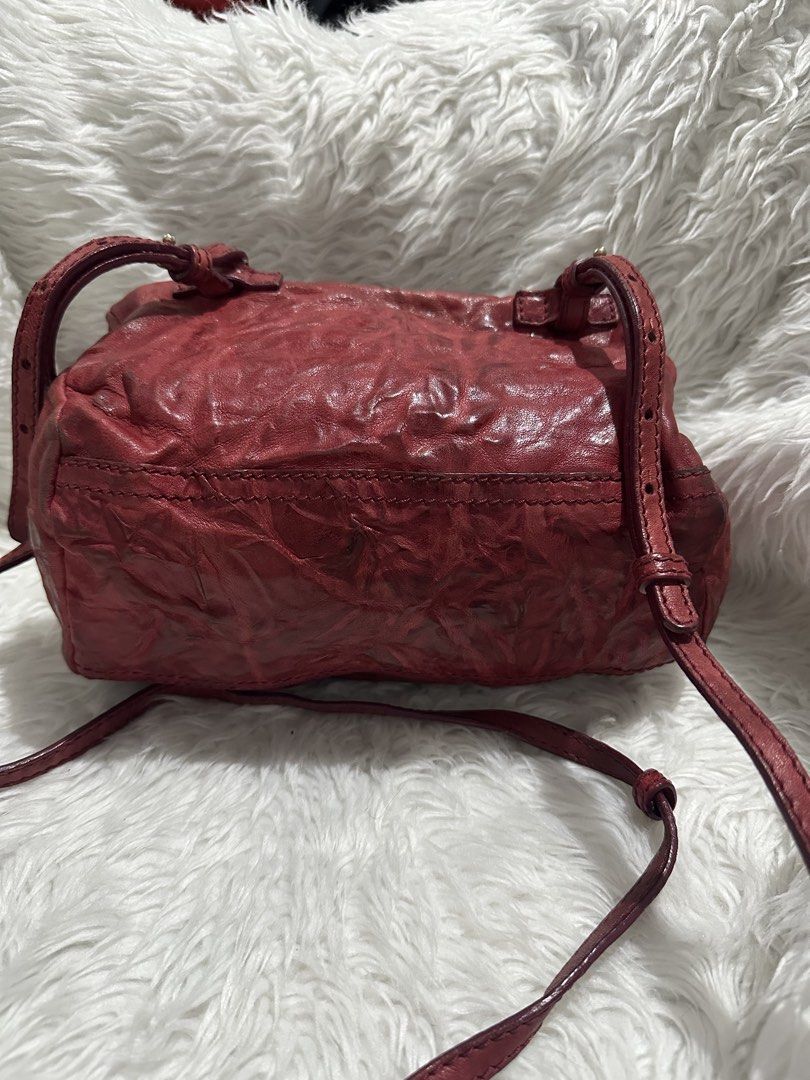 Givenchy Red Leather Pandora Mini Crossbody Bag (Category: Luxury Bags & Wallets) located in Marilao. Submitted by curleylux (Listing ID 1470586768, Image 2). Description: Givenchy Pandora crossbody bag in crinkled red leather. Gold tone hardware and zipper closures. Bold GIVENCHY logo lettering stamped across the front. Adjustable thin strap attached. Boxy silhouette with slight softening at the corners. Minor darkening and scuffing along the lo