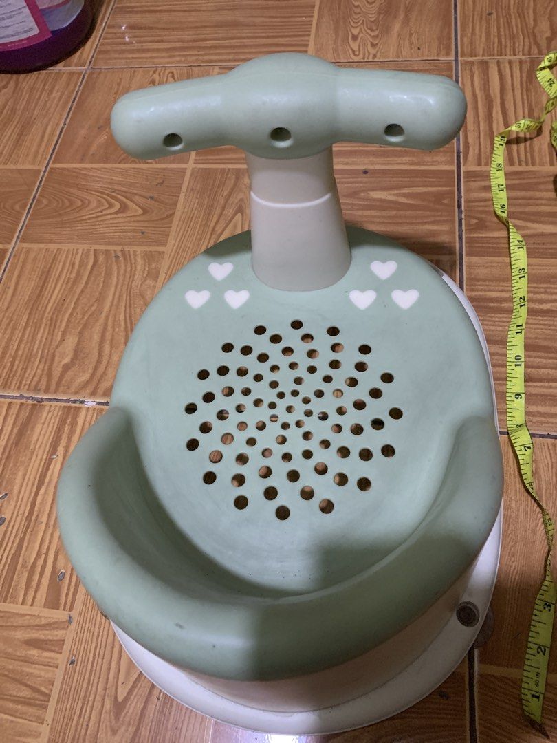 Green baby bath seat with support handle (Category: Bathtub & Bath Accessories) located in Antipolo. Submitted by cebb888 (Listing ID 1470652470, Image 2). Description: - Color: Green and white with cute white heart designs - Stable & Secure: Suction cup base keeps the seat firmly in place inside the tub - Safe Ventilation: Base has ventilation holes for water drainage and airflow - Easy Grip: Support handle features fun circular openings for bet