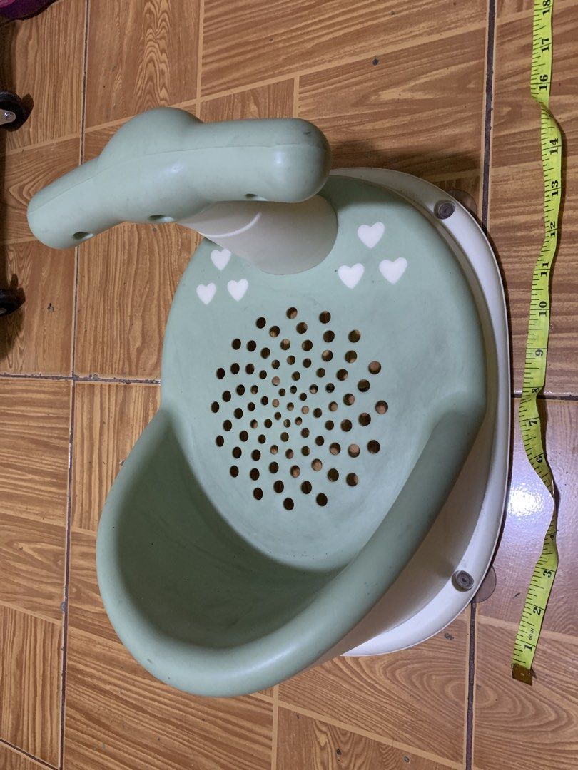 Green baby bath seat with support handle (Category: Bathtub & Bath Accessories) located in Antipolo. Submitted by cebb888 (Listing ID 1470652470, Image 1). Description: - Color: Green and white with cute white heart designs - Stable & Secure: Suction cup base keeps the seat firmly in place inside the tub - Safe Ventilation: Base has ventilation holes for water drainage and airflow - Easy Grip: Support handle features fun circular openings for bet
